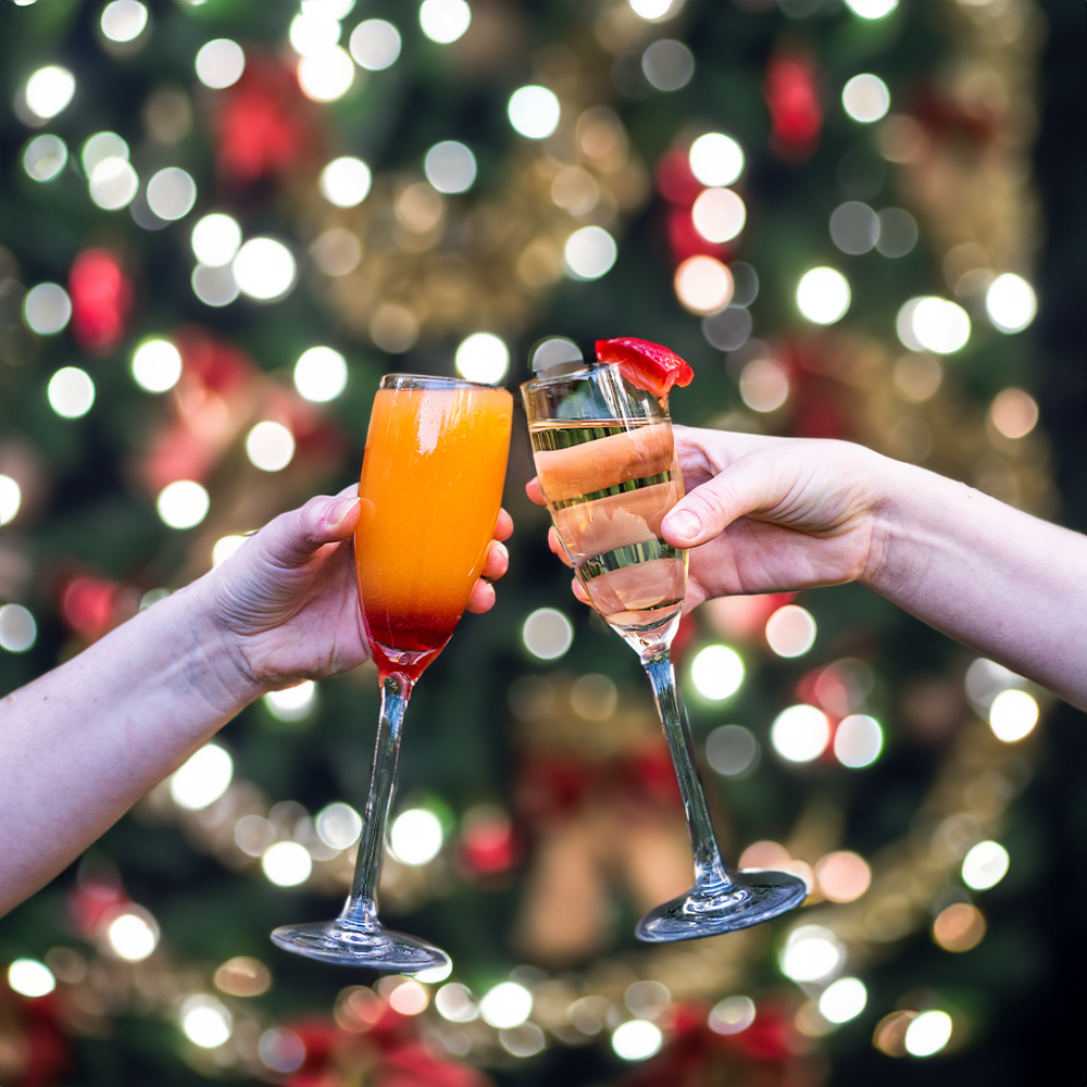 cheers with christmas prosecco and festive coccktail with christmas decorations in the background at our christmas party venue no.4 clifton village