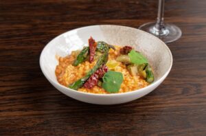 A vibrant vegan sundried tomato risotto served at No.4 Clifton Village, a leading Clifton restaurant in Bristol, topped with roasted asparagus, caramelised leeks, and edible nasturtium leaves. This gluten-free dish highlights seasonal British produce and plant-based fine dining in Bristol’s leafy Clifton neighbourhood, near Berkeley Square and the Clifton Triangle.